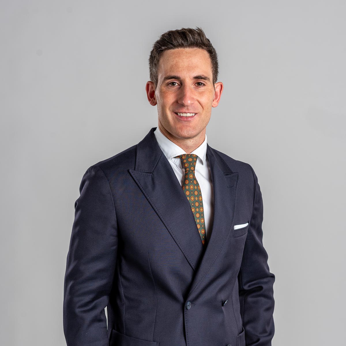 Retrato corporativo de hombre con traje sobre fondo gris realizado en estudio