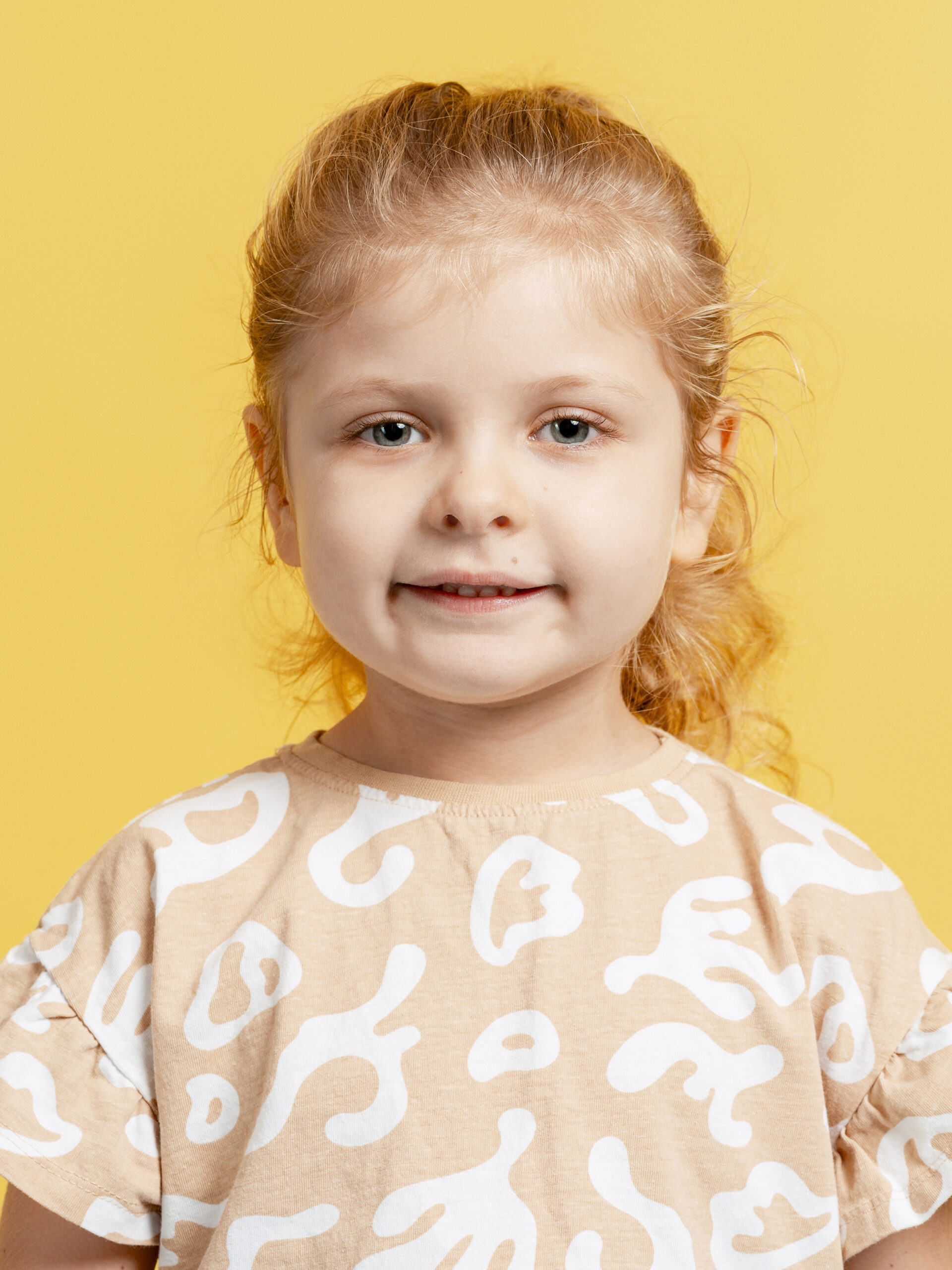 Fotografía documental de niña con fondo neutro y expresión natural